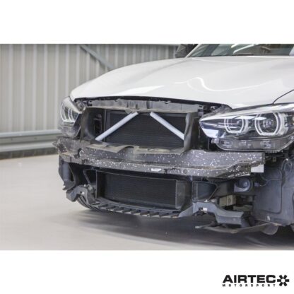 using the OEM mounts and the original coolant connectors. To protect the larger core in its vulnerable position at the front of the car